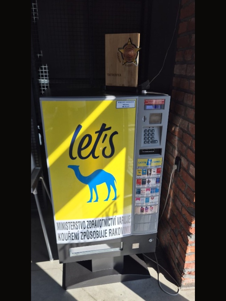Cigaretový automat u cihelné stěny