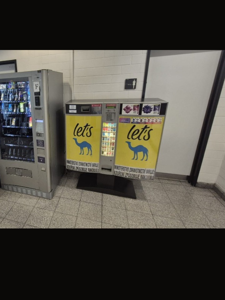Cigaretový automat v řadě prodejních automatů v areálu