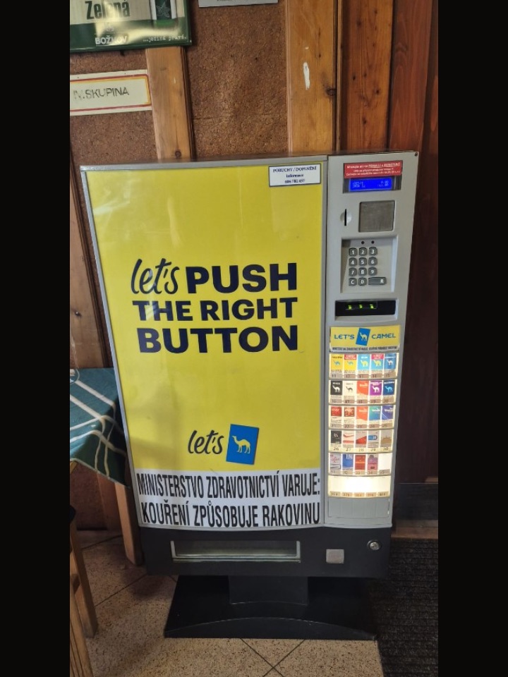 Cigaretový automat v hospodě u dřevěného obkladu