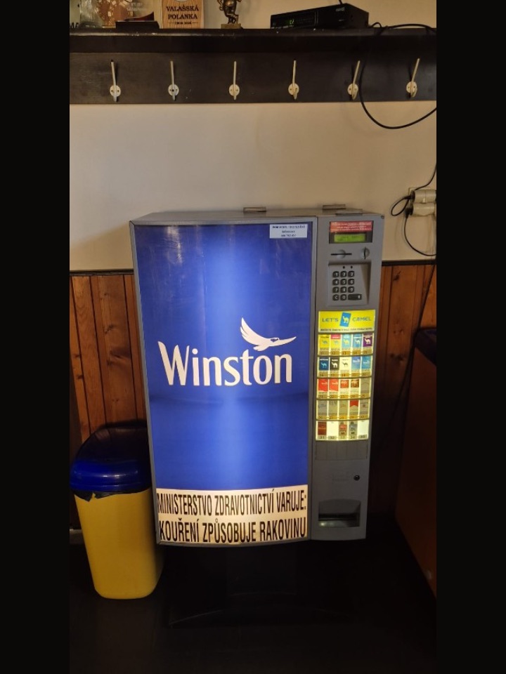 Cigaretový automat v hospodě u dřevěné stěny