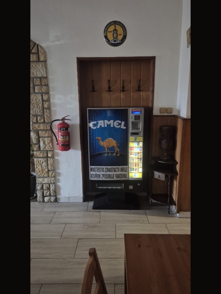 Cigaretový automat v hospodě ve dřevěném výklenku